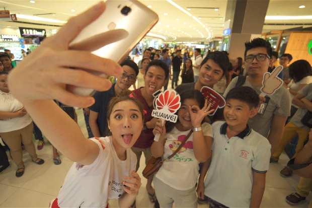 MYX VJ Sunny Kim takes a groufie with some mall-goers using a Huawei GR5 during the first leg of the GR5 Great Selfie Raid at SM North EDSA.